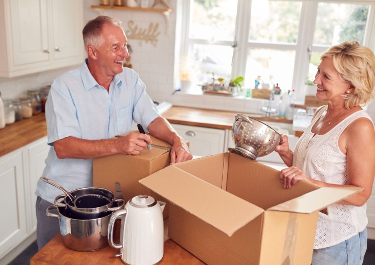 An elderly couple packing boxes in their home